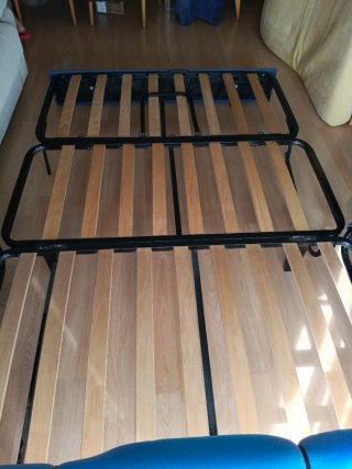 Sofá cama con lamas de madera y estructura tubular