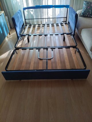 Sofá cama con lamas de madera y estructura tubular