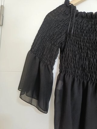 Blusa negra con volantes y manga acampanada