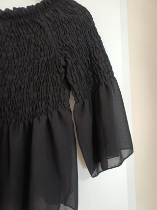 Blusa negra con volantes y manga acampanada