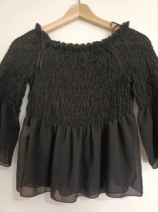 Blusa negra con volantes y manga acampanada