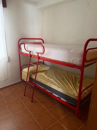 Cama litera metálica roja y amarilla. En Almuñécar