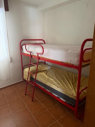 Cama litera metálica roja y amarilla. En Almuñécar