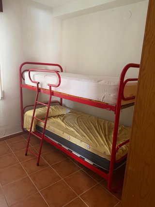 Cama litera metálica roja y amarilla. En Almuñécar