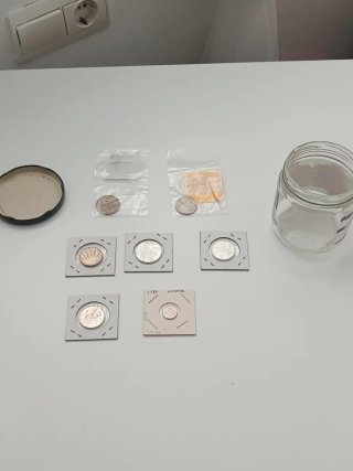 Lote de monedas antiguas en frasco de cristal.