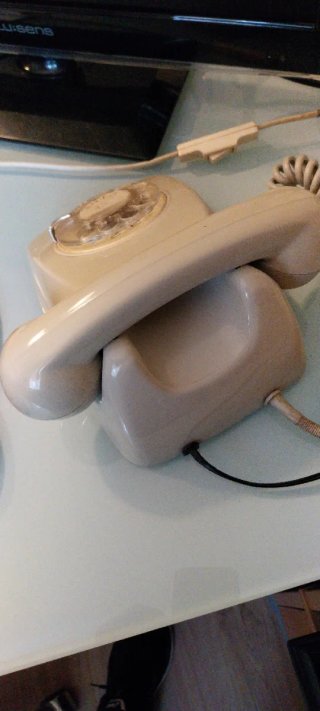 Teléfono antiguo de disco beige años 70