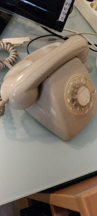 Teléfono antiguo de disco beige años 70