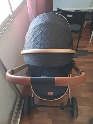 Carrito de bebé negro y dorado