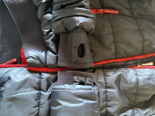 Parka infantil negra con detalles rojos