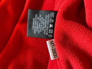 Parka infantil negra con detalles rojos