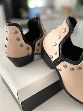 Botín beige con tachuelas y detalles negros