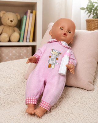Bebé tipo Nenuco con pijama rosa y biberón