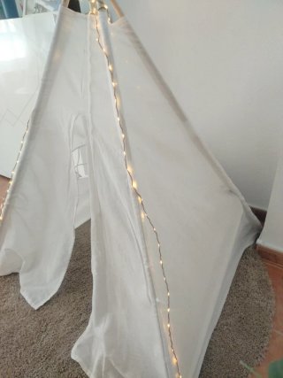 Tipi blanco con luces y alfombra