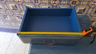 Mesita de noche azul con tiradores dorados,