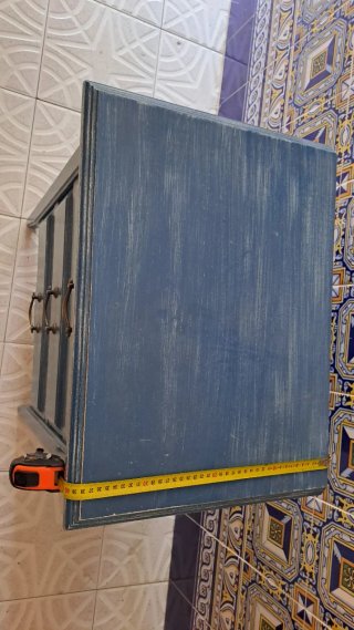 Mesita de noche azul con tiradores dorados,