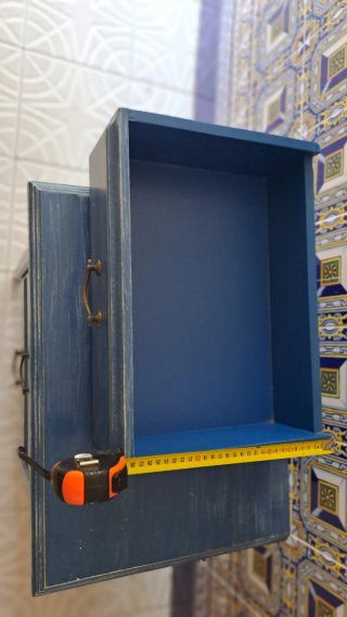 Mesita de noche azul con tiradores dorados,