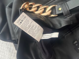 Pantalón efecto piel con cadena dorada