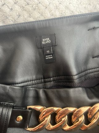 Pantalón efecto piel con cadena dorada
