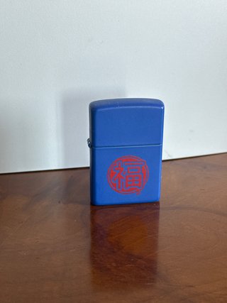 Zippo azul con símbolo rojo