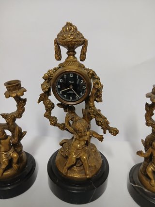 Reloj y candelabros de bronce con querubines