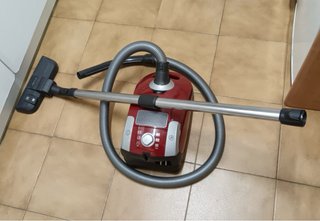 Aspiradora roja con tubo y cepillo