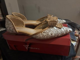 Zapatos planos beige y plateados con lazo