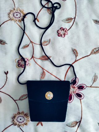 Bolso de terciopelo negro con adorno dorado