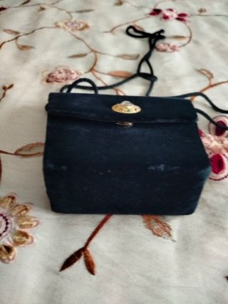 Bolso de terciopelo negro con adorno dorado