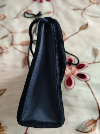 Bolso de terciopelo negro con adorno dorado