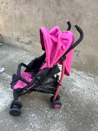 Cochecito de bebé rosa con plástico de lluvia