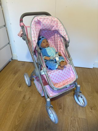 Cochecito de muñecas rosa con bebé