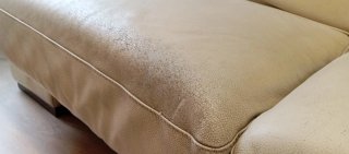Sofá de piel beige desgastado