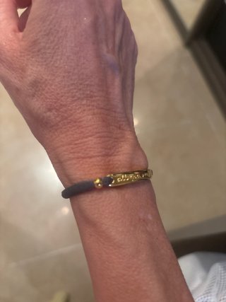 Pulsera dorada con cordón gris