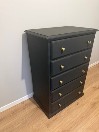 Cómoda de madera negra con tiradores dorados