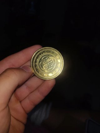 Moneda antigua dorada con diseño floral de oro