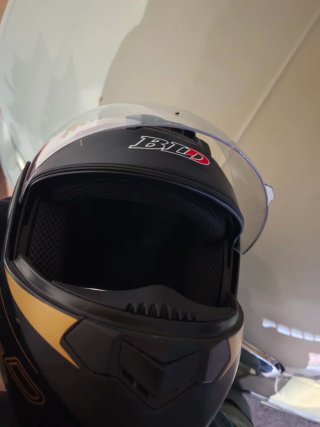 Casco de moto negro y dorado