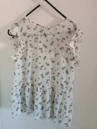 Blusa blanca con volantes y estampado floral
