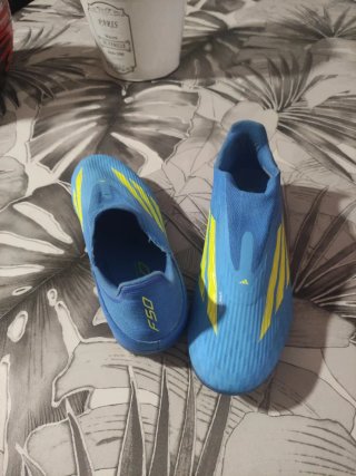 Botas de fútbol niño azul y amarillo.