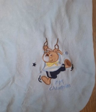 Saco de bebé azul con dibujo.