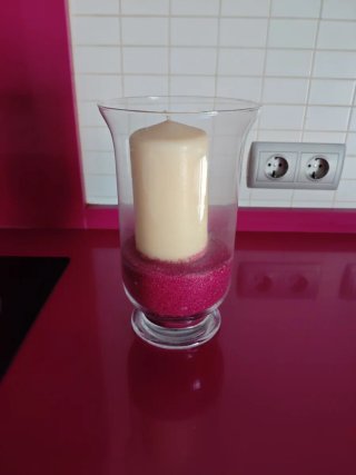Jarrón de cristal con vela y arena rosa