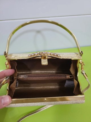 Bolso de mano dorado con pedrería