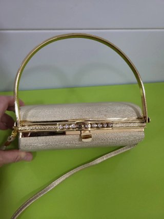 Bolso de mano dorado con pedrería