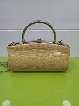 Bolso de mano dorado con cadena