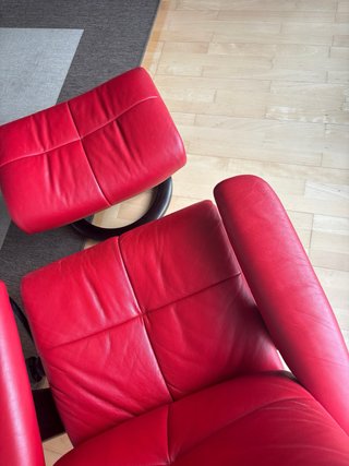 Sillón de piel rojo con reposapiés.