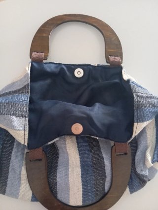 Bolso de rayas con asas de madera.