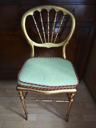 Silla de madera dorada con asiento verde