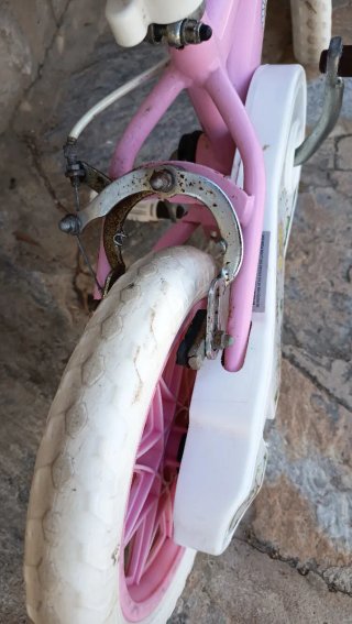 Bicicleta infantil rosa con ruedas blancas