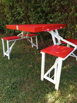 Mesa plegable roja con sillas