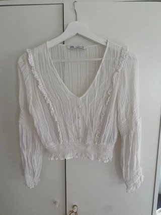 Blusa blanca con botones. Le falta un botón