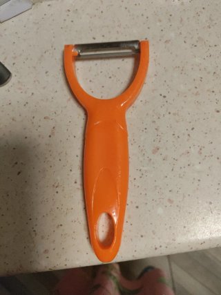 Pelador de patatas y frutas naranja